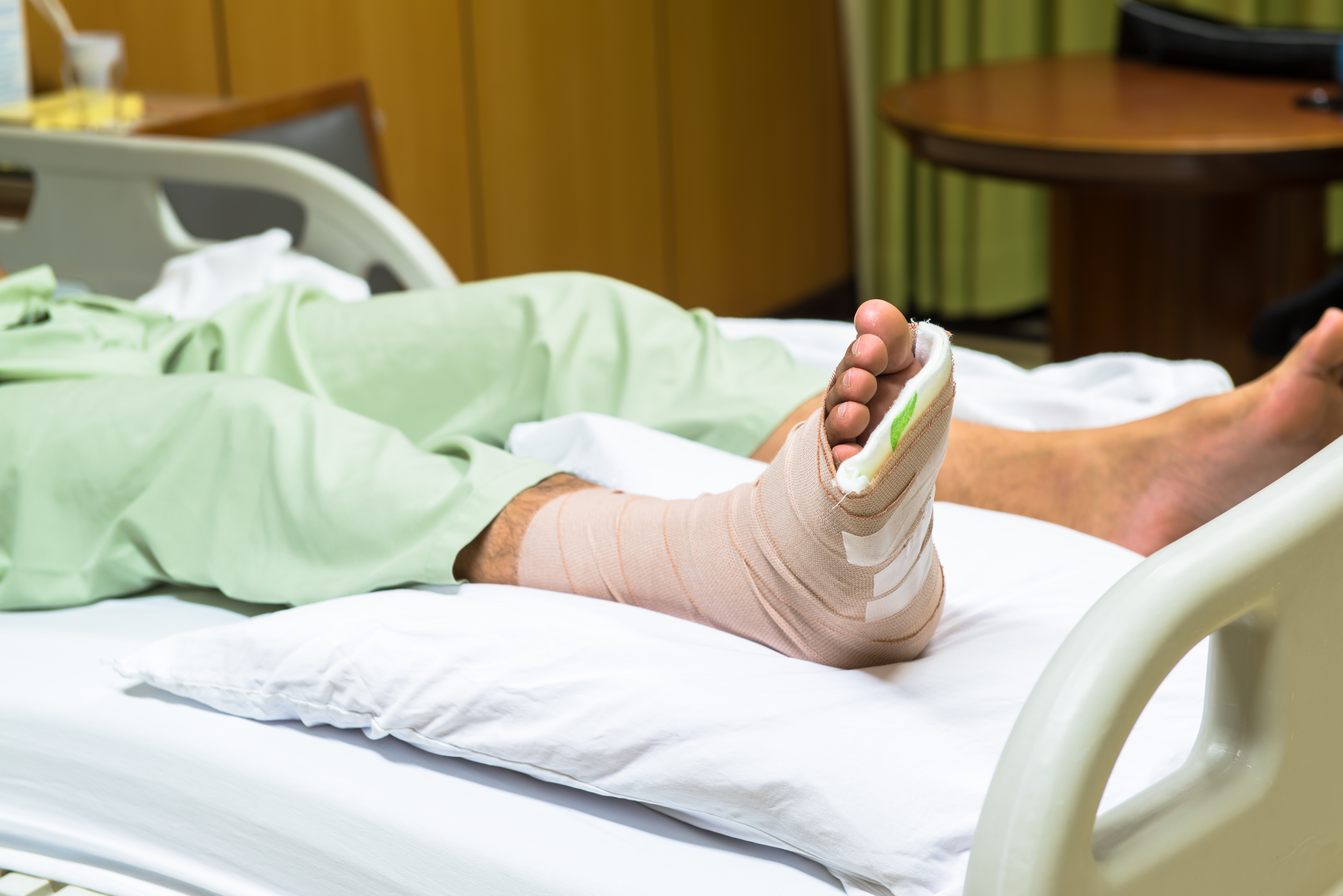 Patient with injured foot in hospital bed
